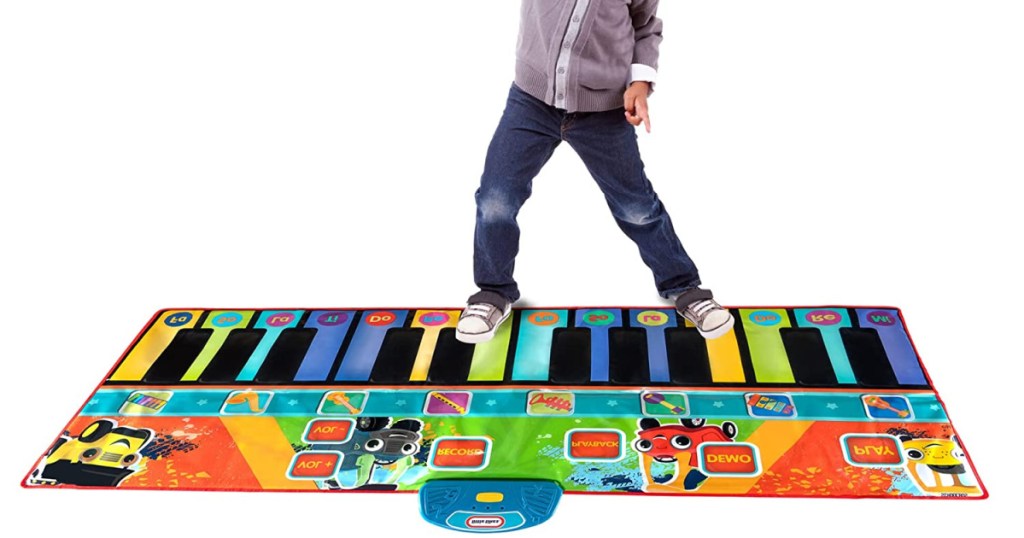 boy playing on giant piano mat