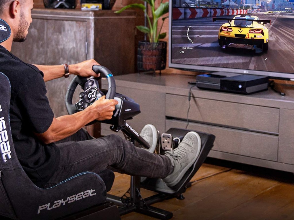 playing a racecar video game with a steering wheel and pedals
