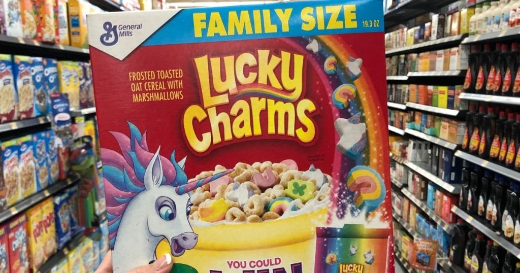 hand holding a box of Lucky Charms