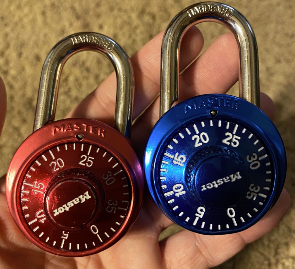 person holding two master locks