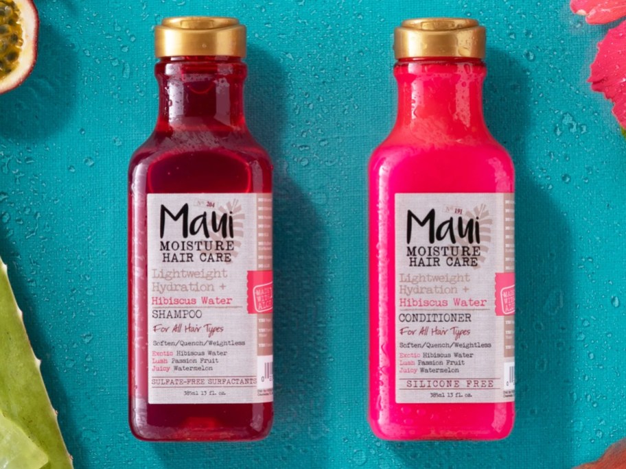 pink bottles of Maui Moisture Hibiscus Water Shampoo & Conditioner on a blue background