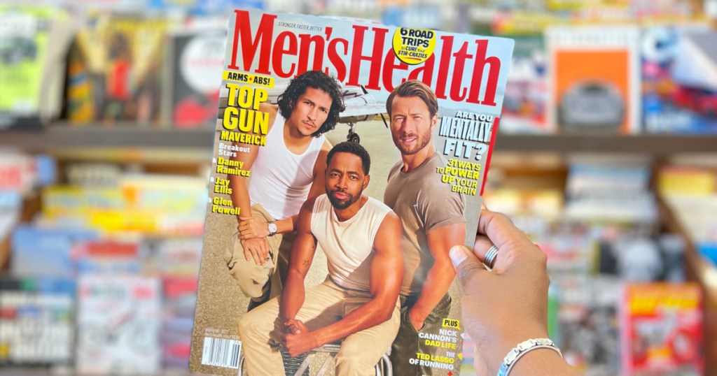person holdimg up copy of Mens Health Magazine inside a store