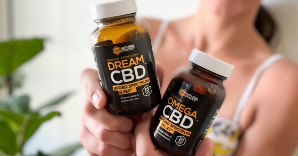 woman holding two bottles of Natural Stacks CBD