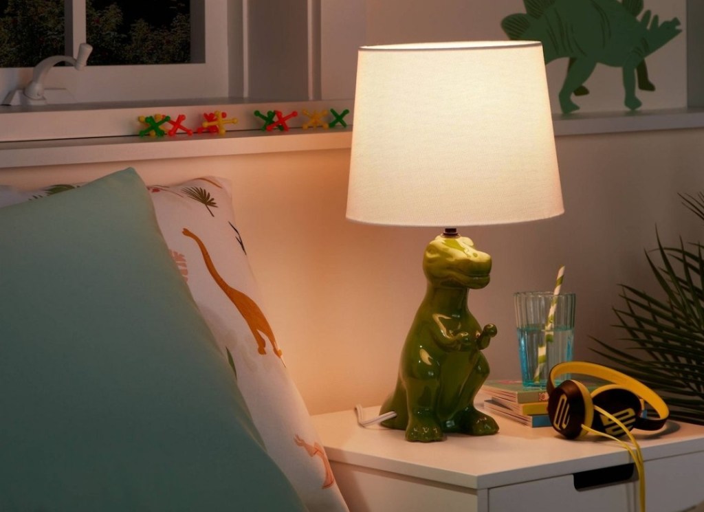 Pillowfort Dinosaur Table Lamp next to a bed