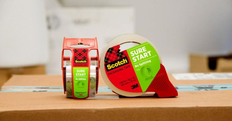 two rolls of scotch sure start packaging tape sitting on top of a packing box