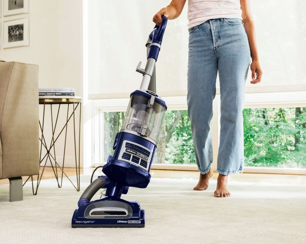 woman using blue shark vacuum