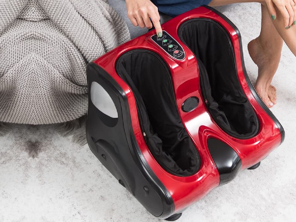 woman pressing buttons on red and black foot massager