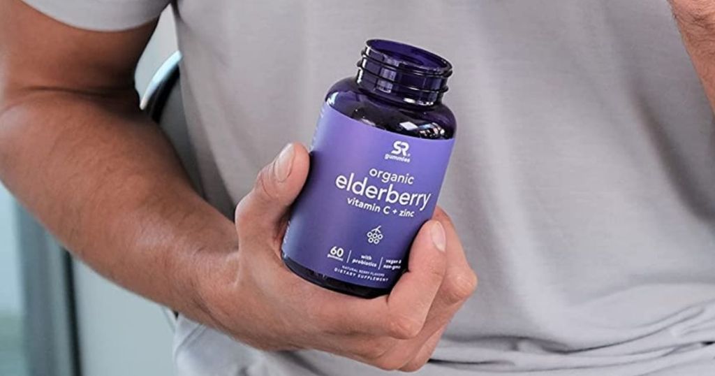 man holding a bottle of Elderberry vitamins