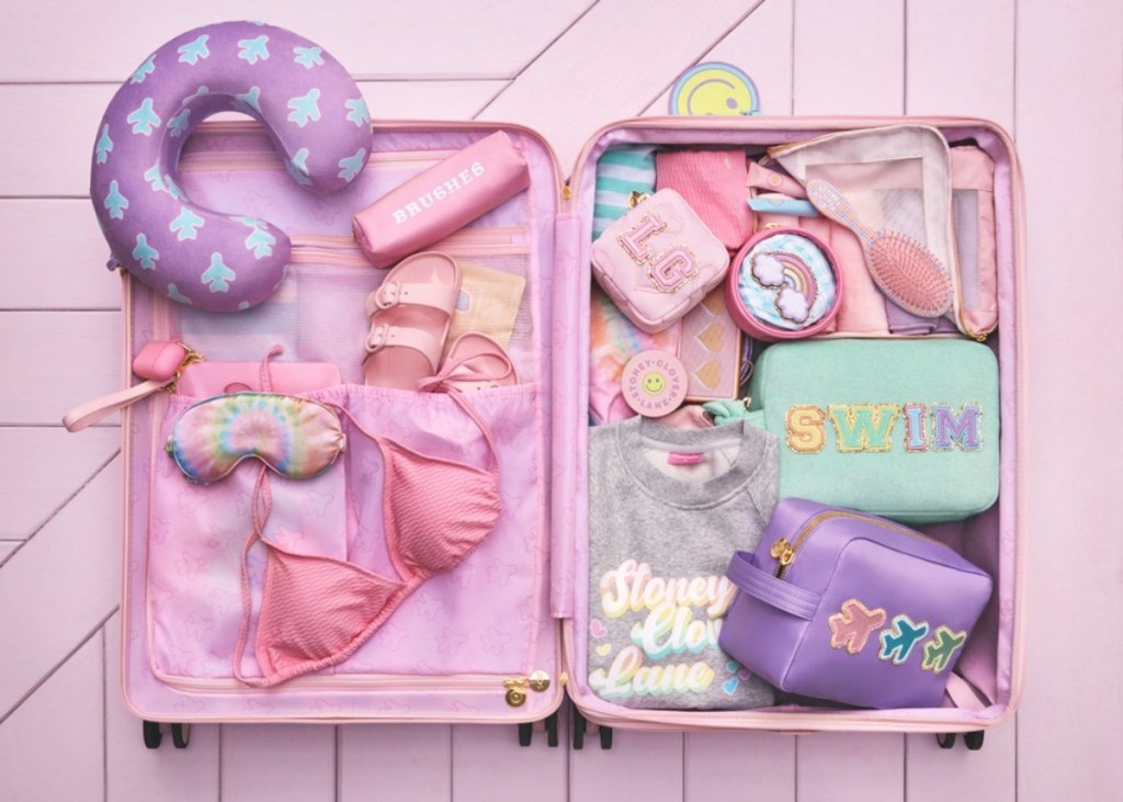 pastel luggage packed with pastel summer gear
