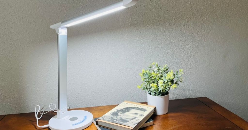 desk lamp by books and a plant