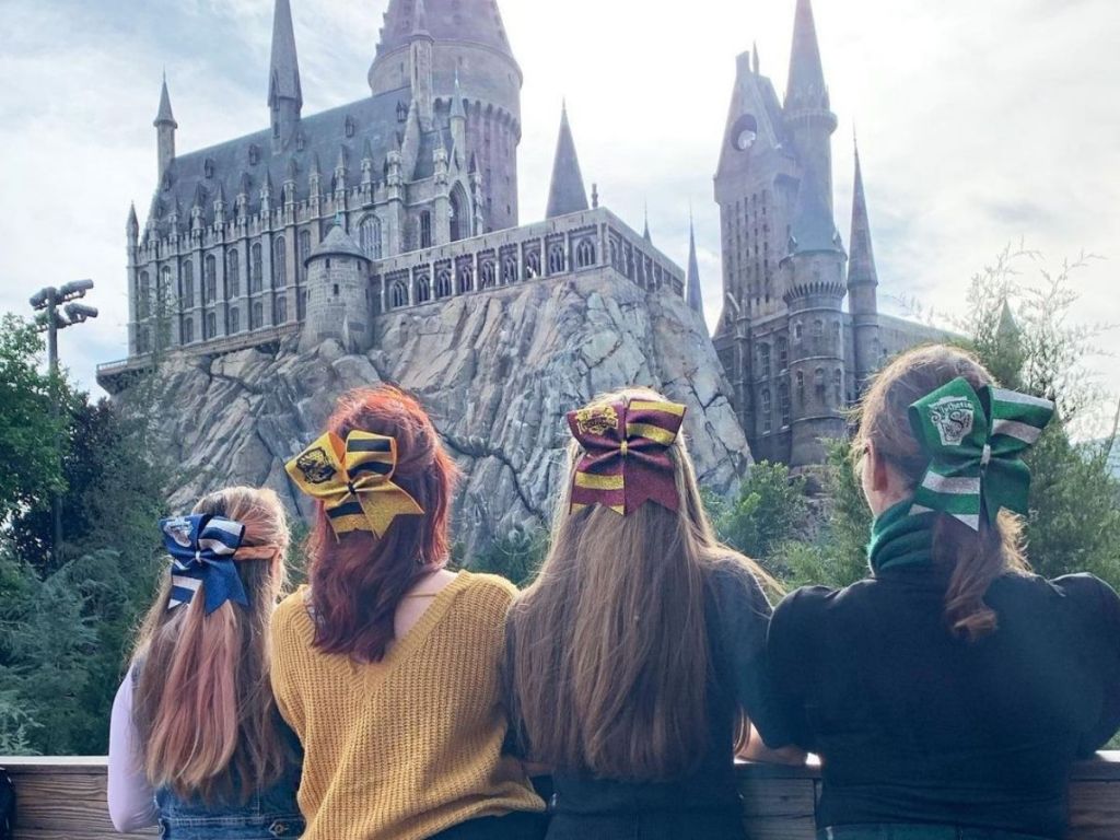 4 girls wearing hogwarts colors looking at hogwarts castle at Universal Orlando