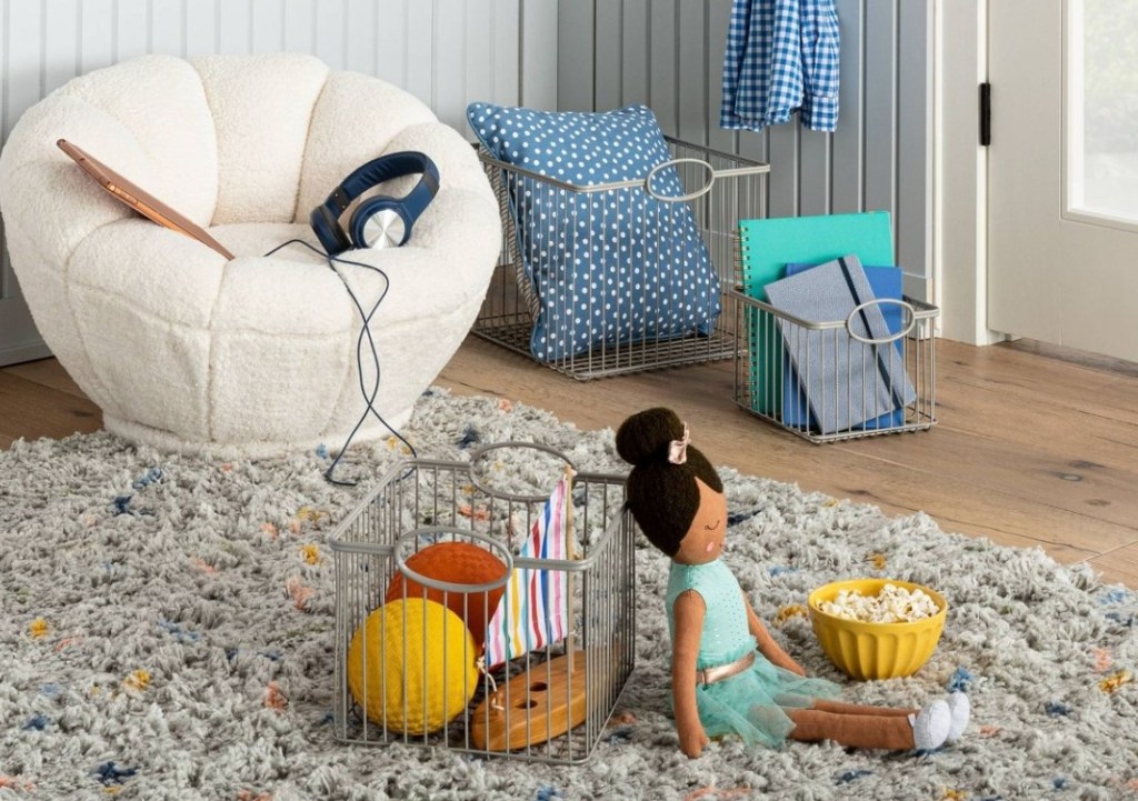 kids room with toys in wire baskets by a chair