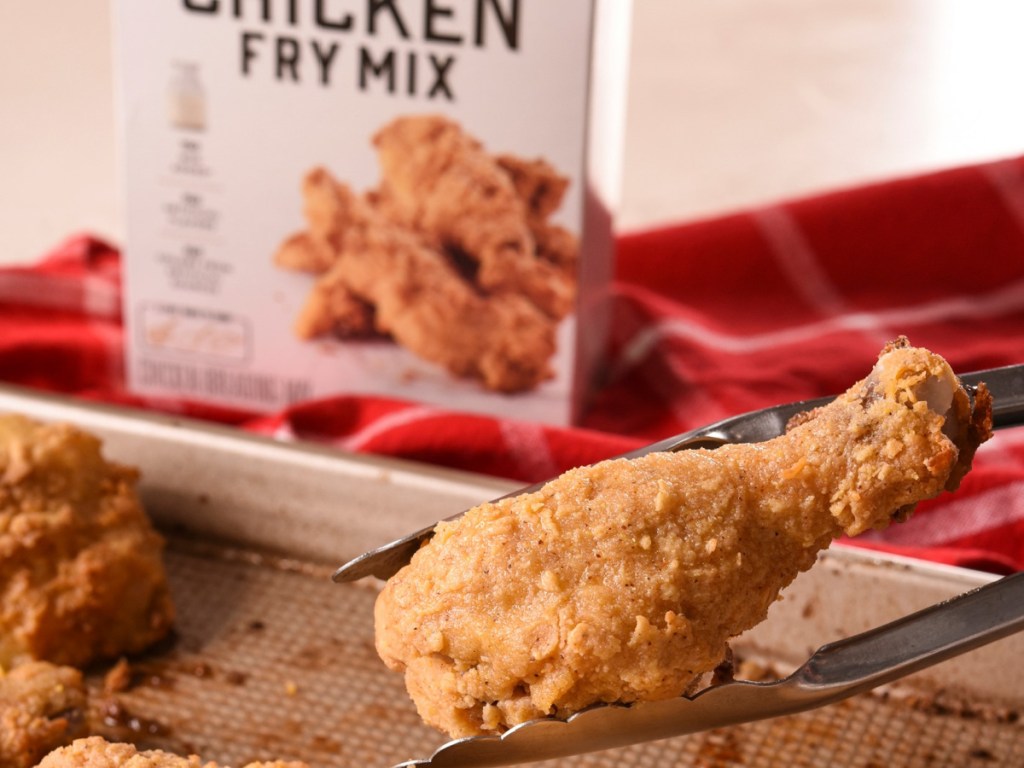 box of chicken fry mix and tongs holding piece of fried chicken