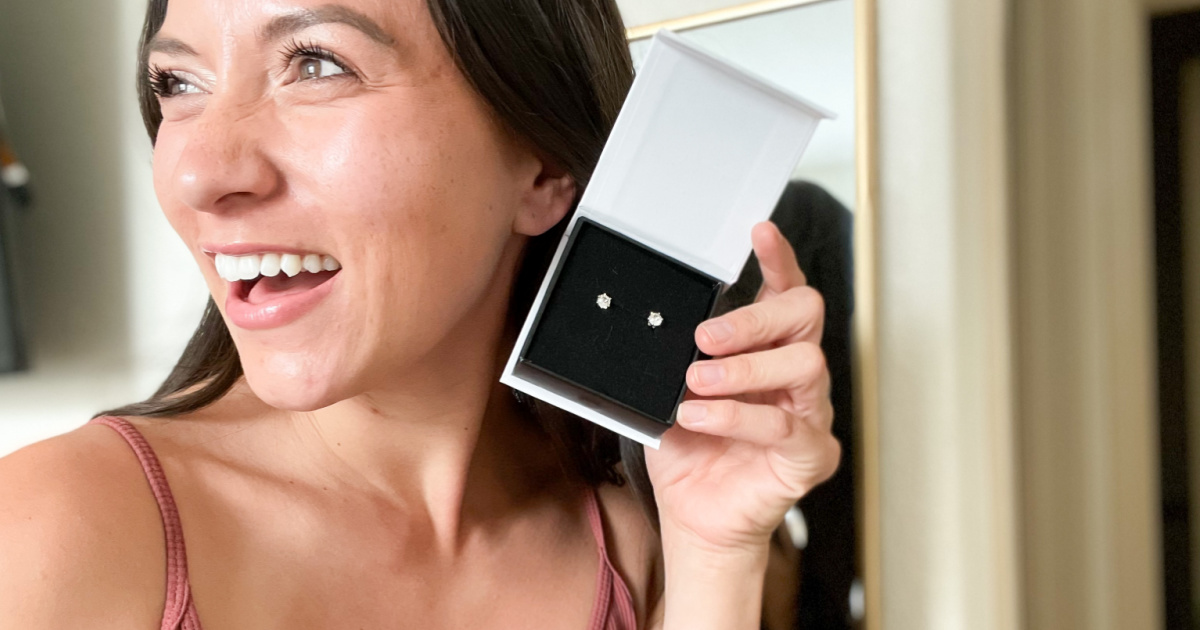 woman holding earring box to ear