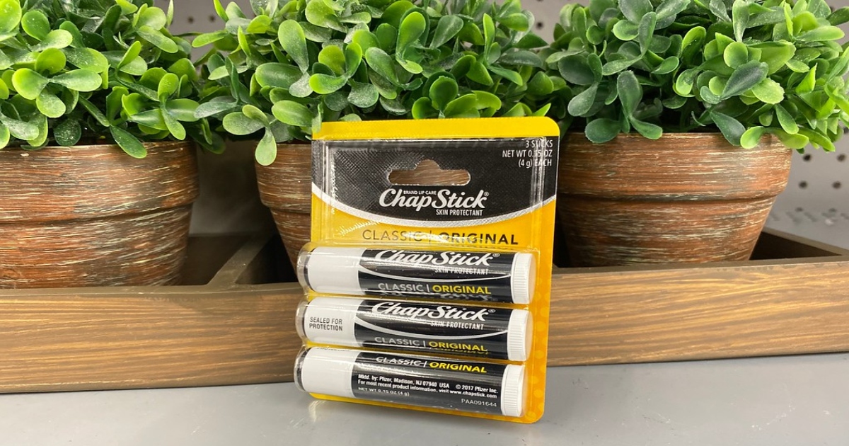 3 pack of original chapstick leaning infront of 3 small potted plants