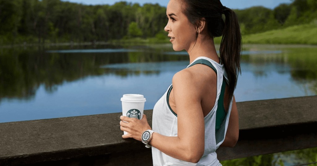 woman wearing Garmin watch and holding Starbucks drink