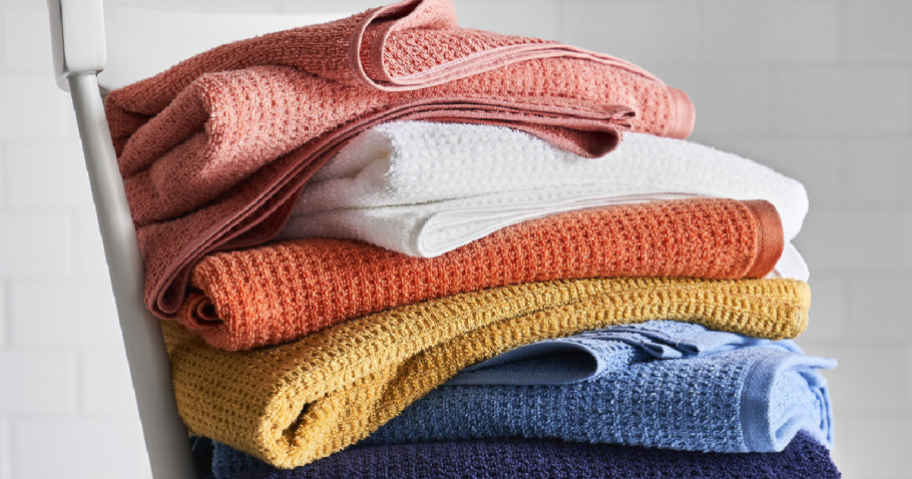 chair with several different colors of towels stacked on it