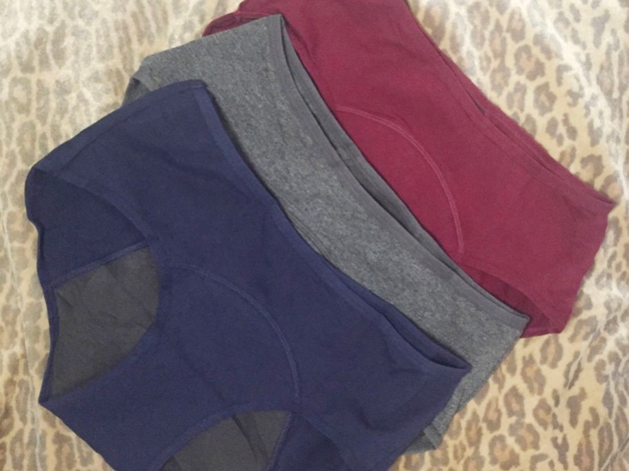 blue, gray, and red underwear laid on bed