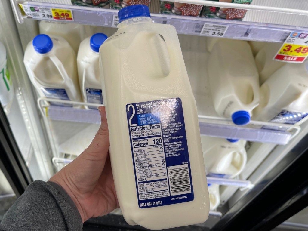 holding a half gallon of milk