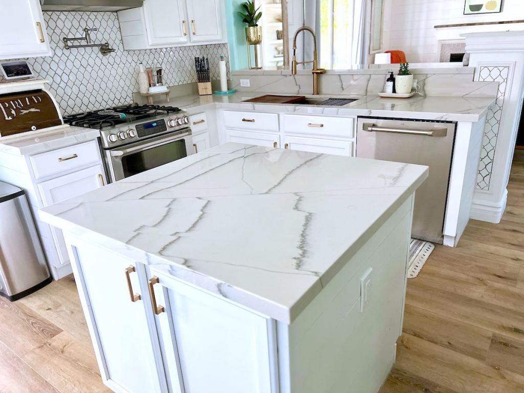 kitchen with white countertops and cabinets with gold hardware