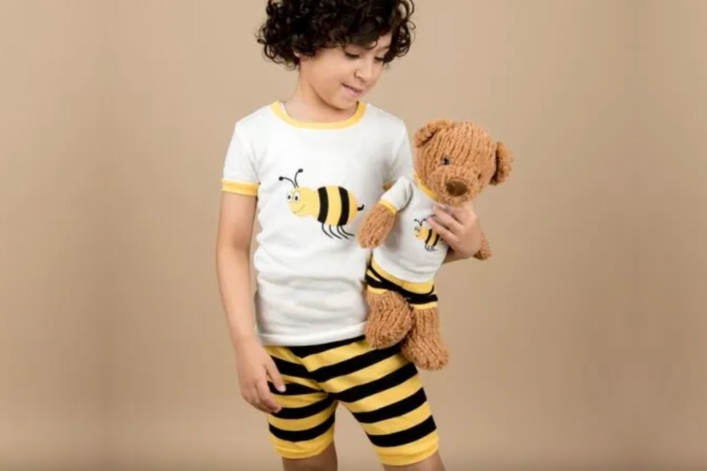boy wearing matching bee pajamas with teddy