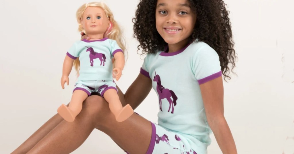 girl wearing unicorn pajamas with doll