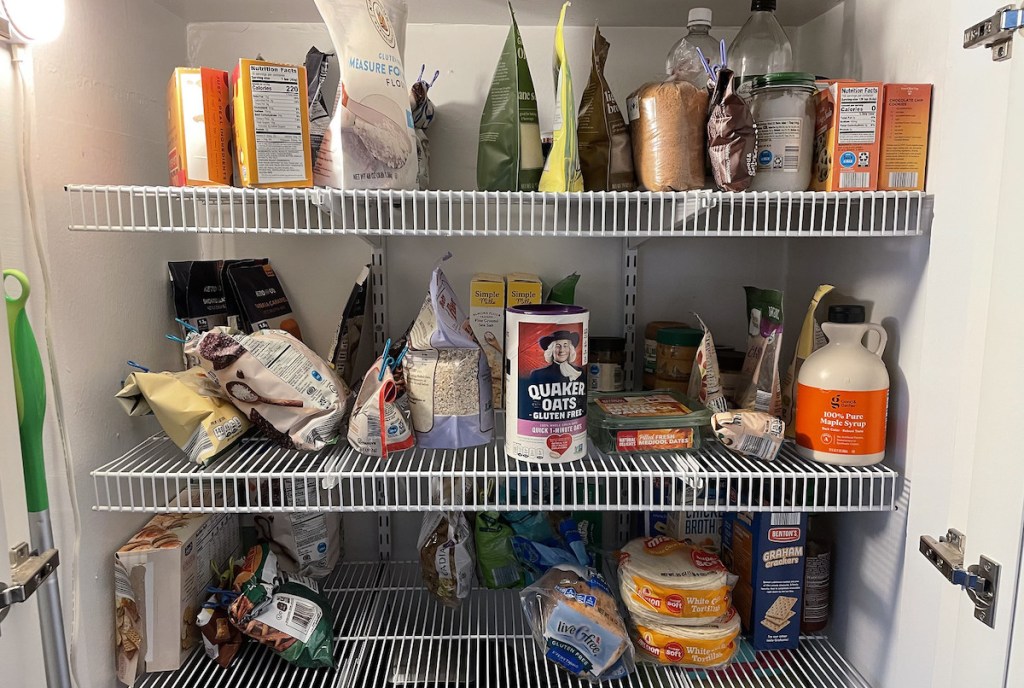 messy unorganized pantry with bags and boxes of food on wire shelving