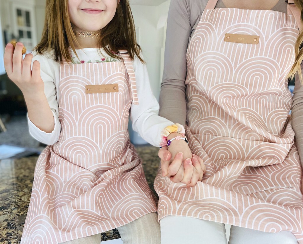 mom and daughter holding hands sitting on countertop