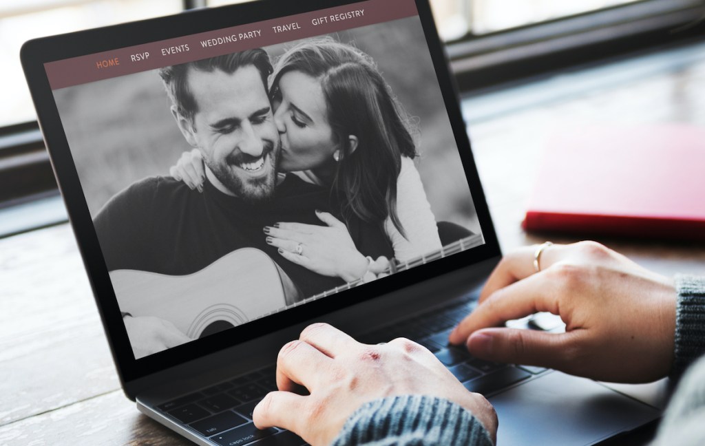 hands typing on keyboard with black and white photo of couple kissing