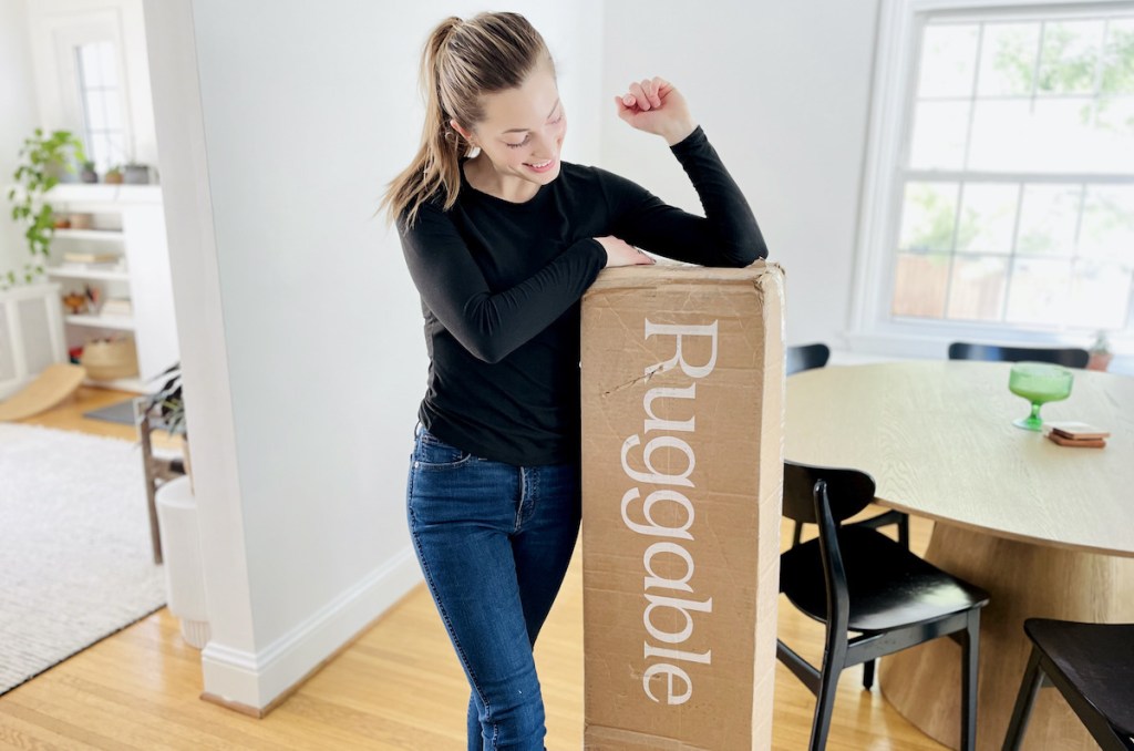 woman with elbow on top of brown ruggable box standing in dining room
