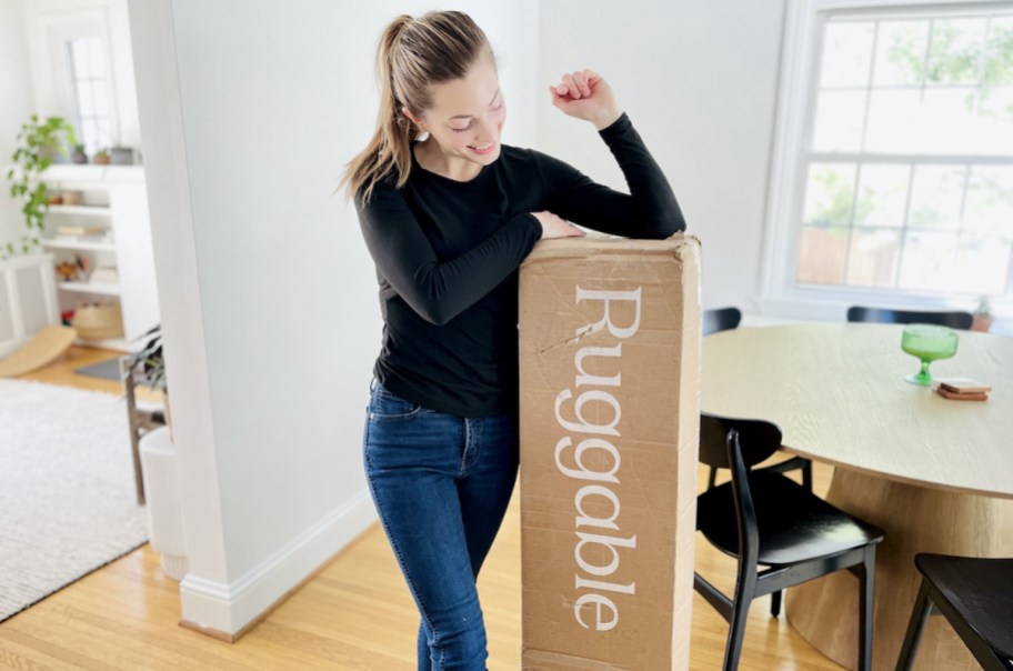 woman with elbow on top of brown ruggable box standing in dining room