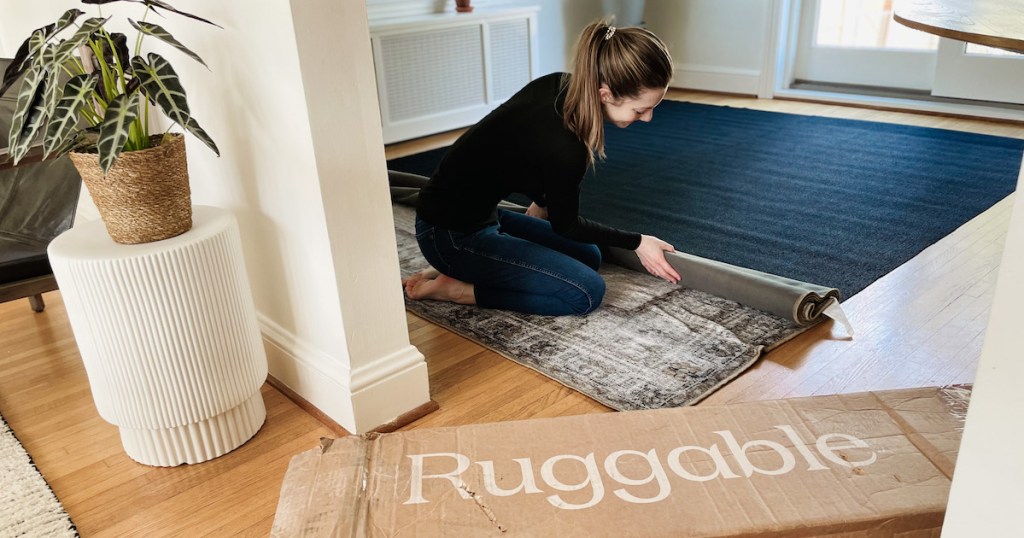 woman rolling out vintage rug on floor with ruggable box
