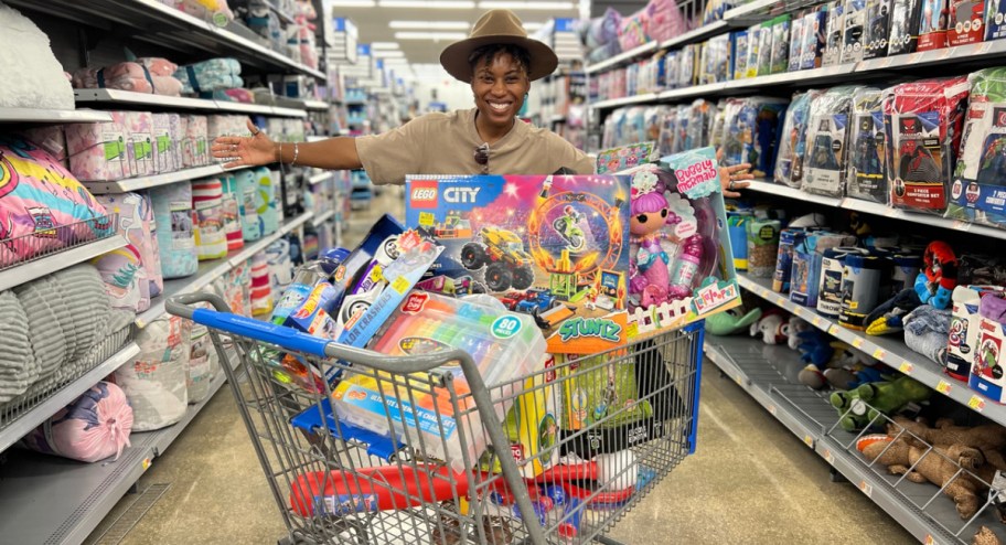 woman standing behind walmart shopping cart filled with toys