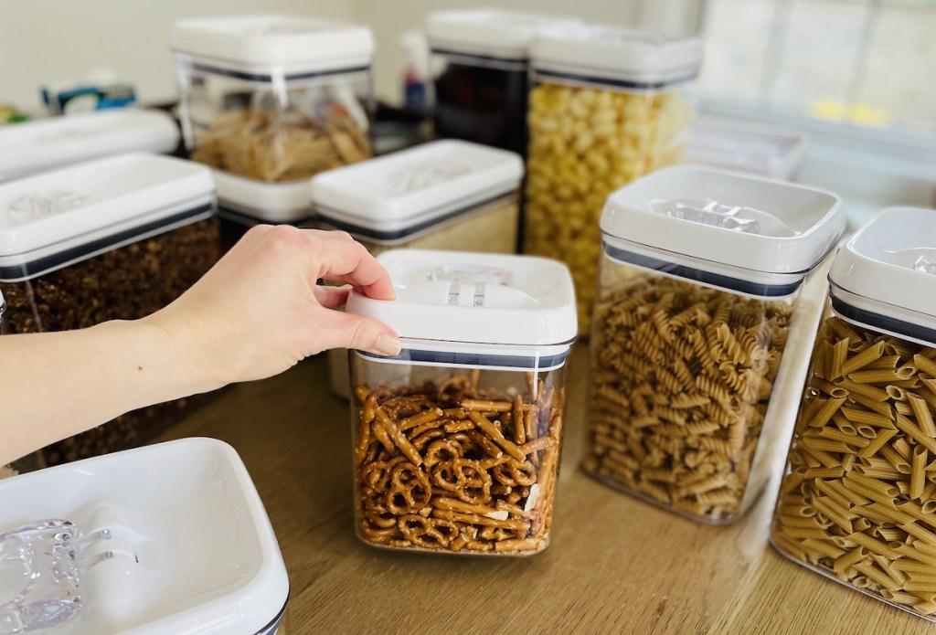 hand holding clear container of pretzels