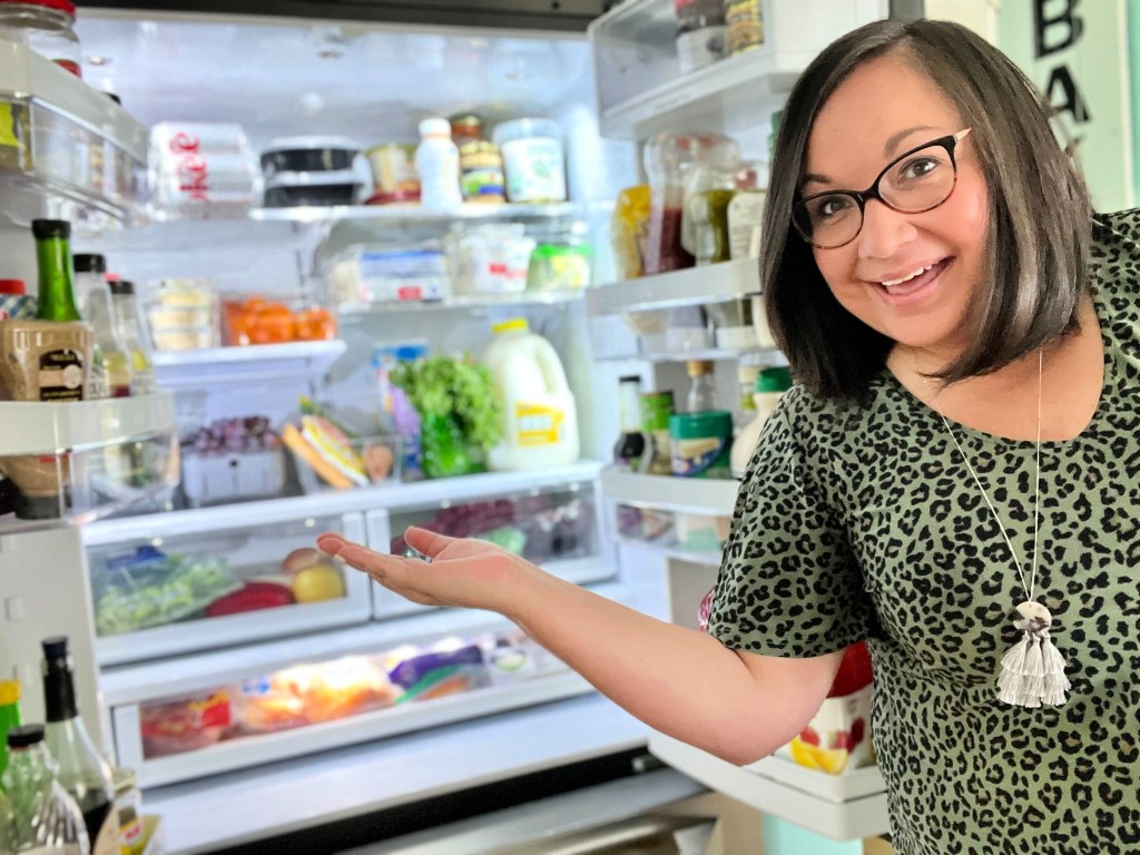 woman pointing to clean fridge