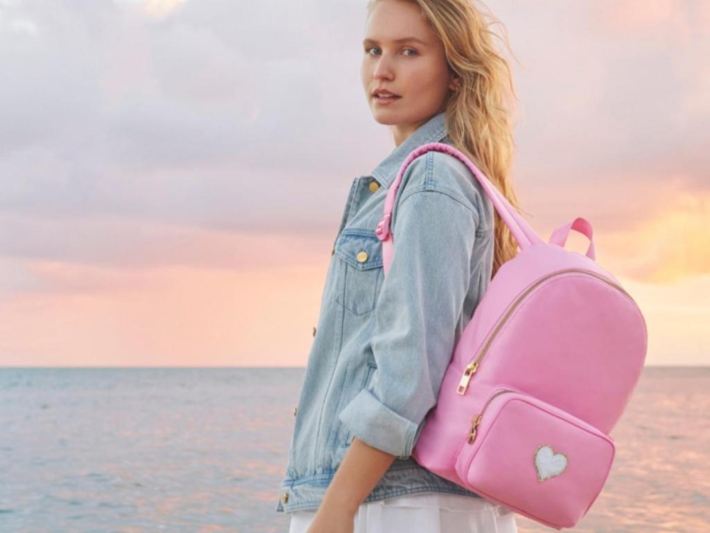 woman wearing pink backpack on beach