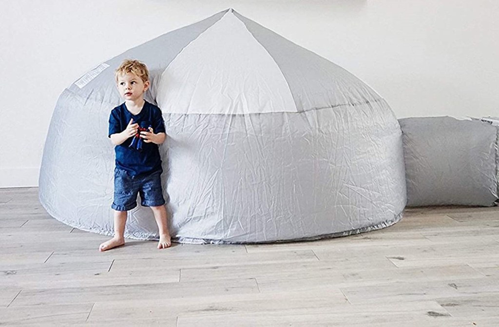 boy standing by an inflatable tent
