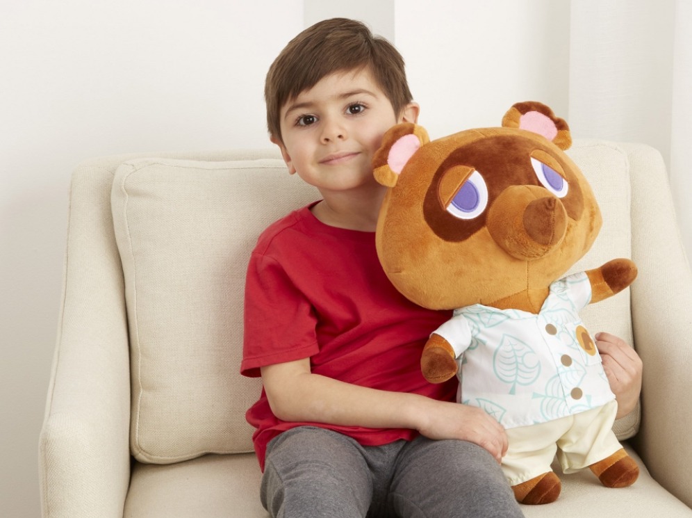 boy holding an Animal Crossing Tom Nook plush