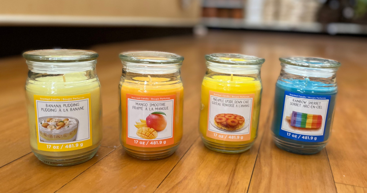 four jar candles on wood floor