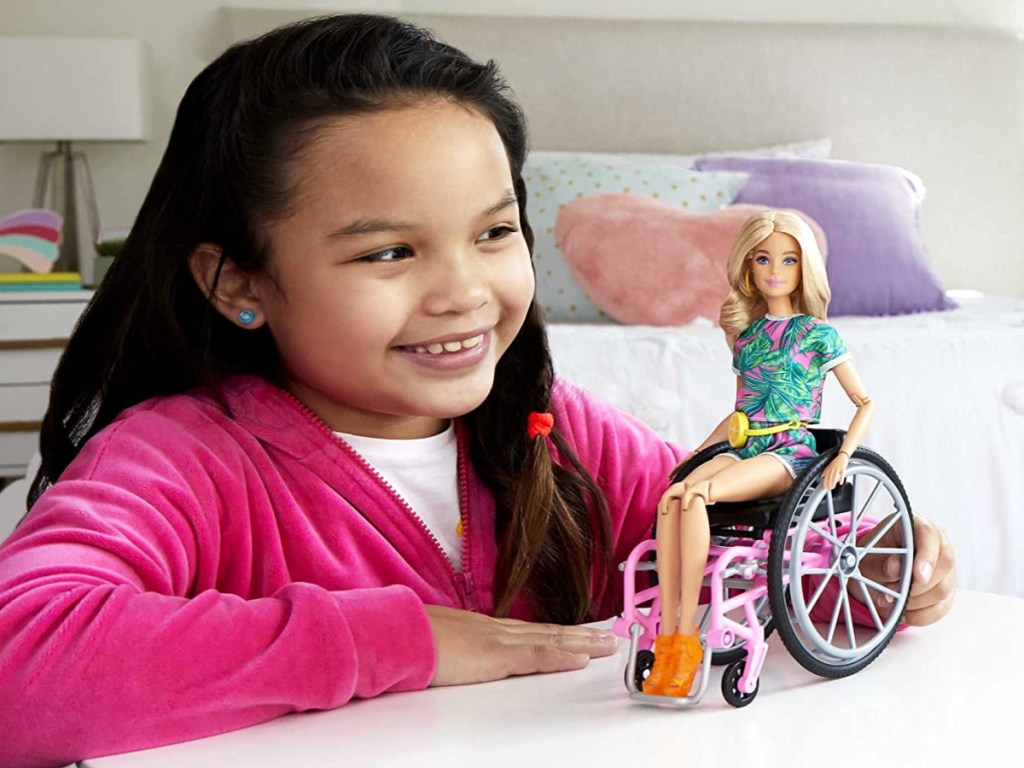 girl playing with Barbie in a wheelchair