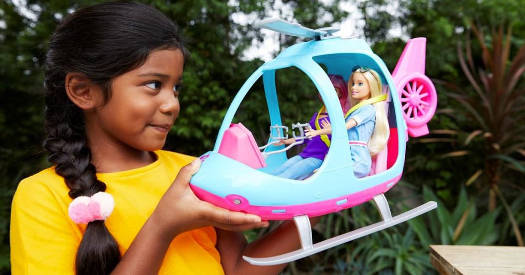 girl holding up barbie helicopter