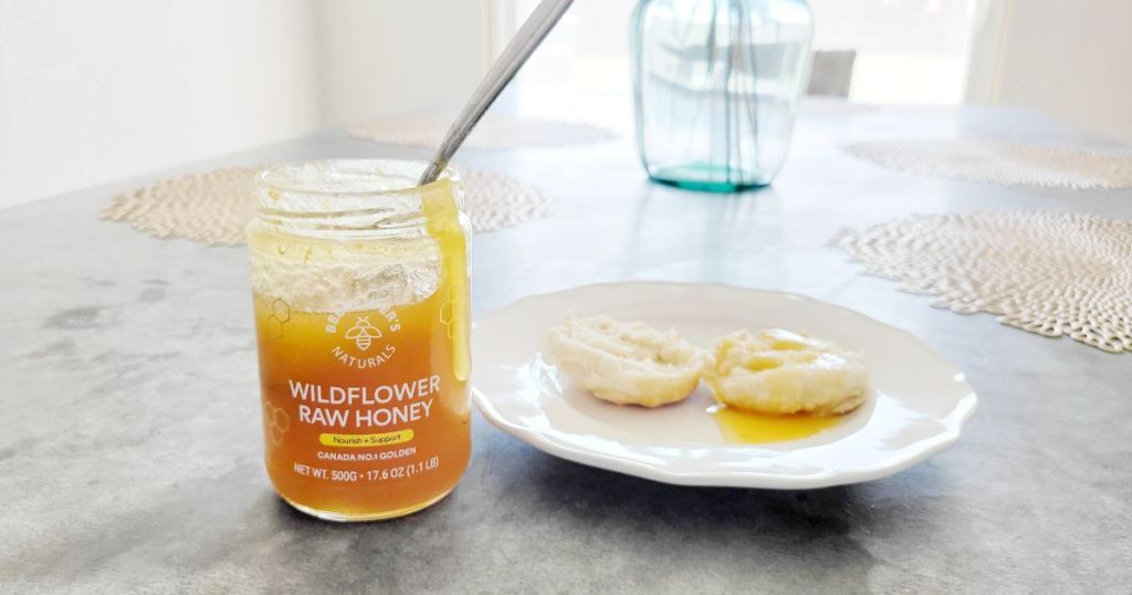 Beekeeper's Naturals Wildflower Honey jar beside biscuits