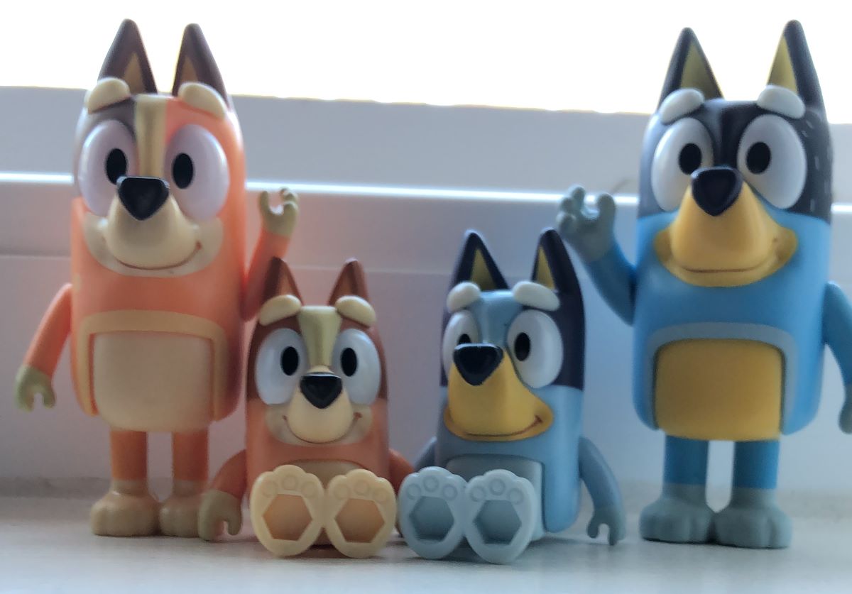 four Bluey figures grouped together on a windowsill
