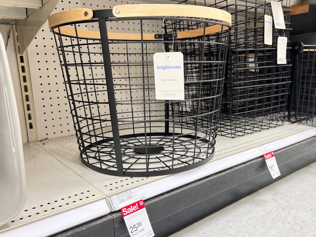 black wire storage basket with wood handle on store shelf