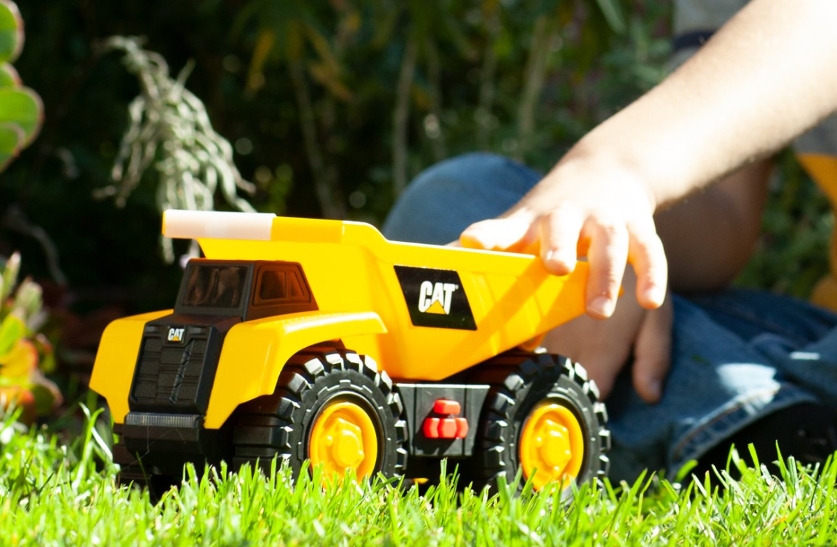 child playing with a CAT dump truck toy