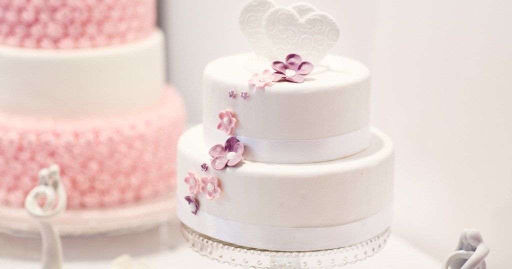 white cake on double tiered stand with heart on top