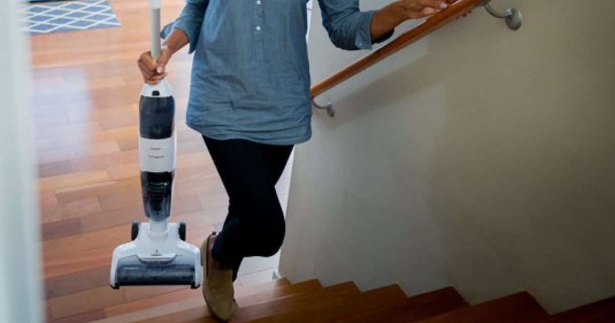 Lady carrying wet/dry vacuum up stairs