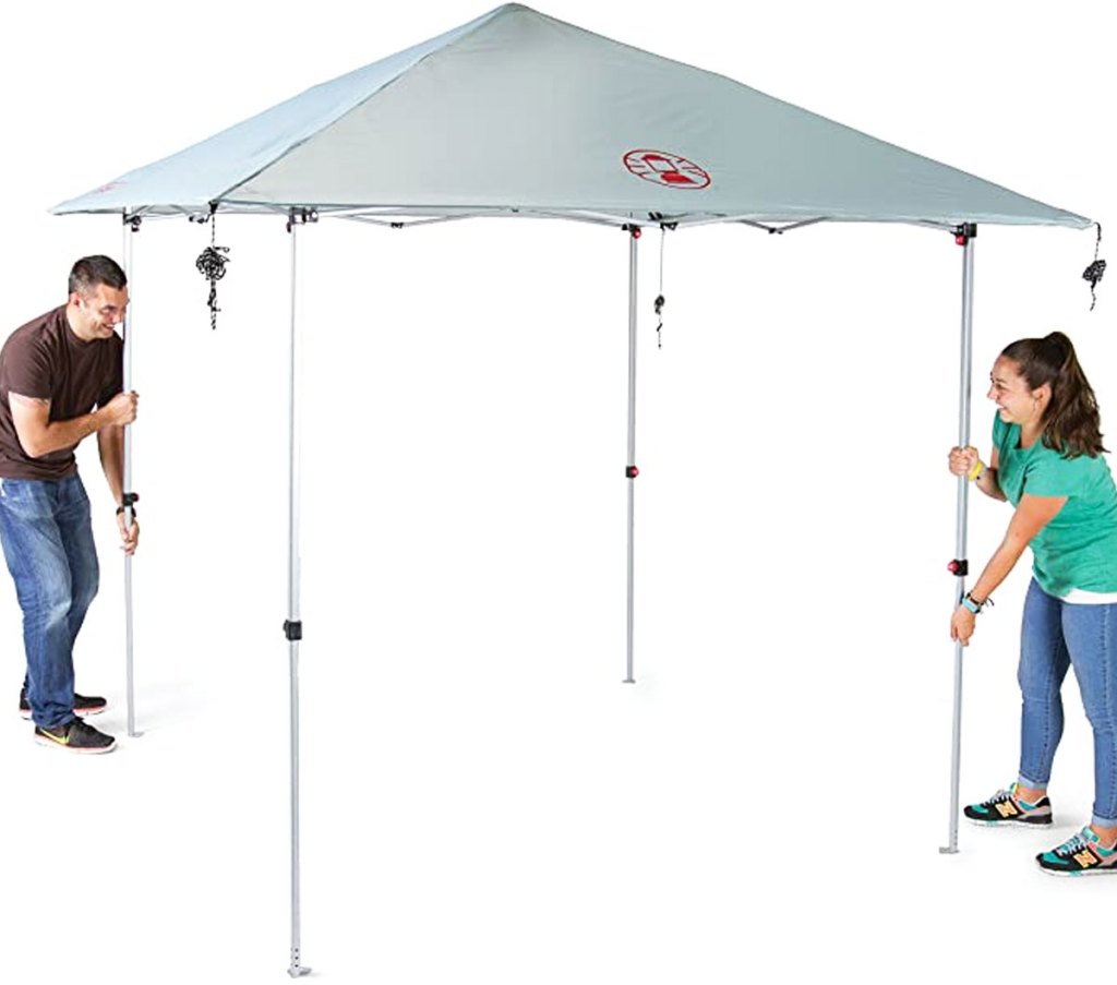 two people setting up outdoor canopy