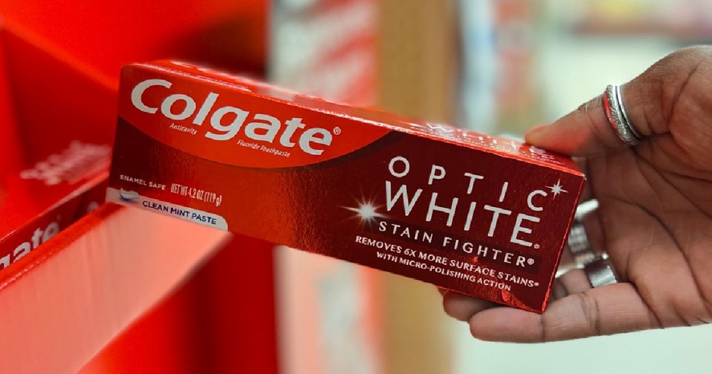 hand holding a package of Colagte Optic White Toothpaste