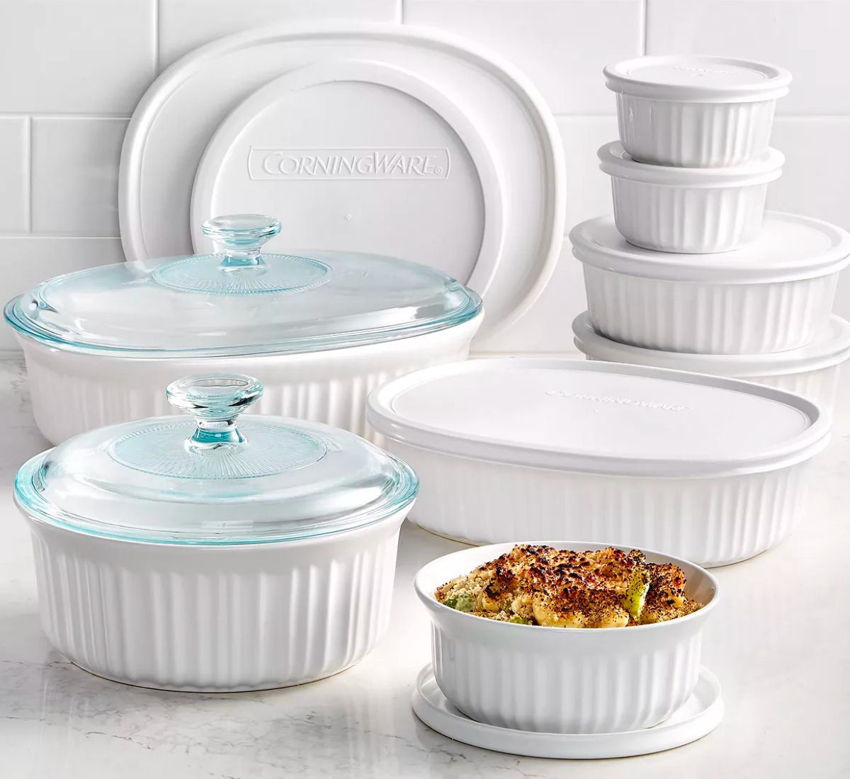 Corningware French White 18-Piece Bakeware Set stacked with lids on a white kitchen counter